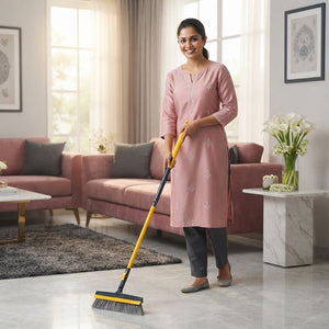 A smiling South Asian woman holding a 2-in-1 floor scrub brush and wiper in a bright, elegant home setting.